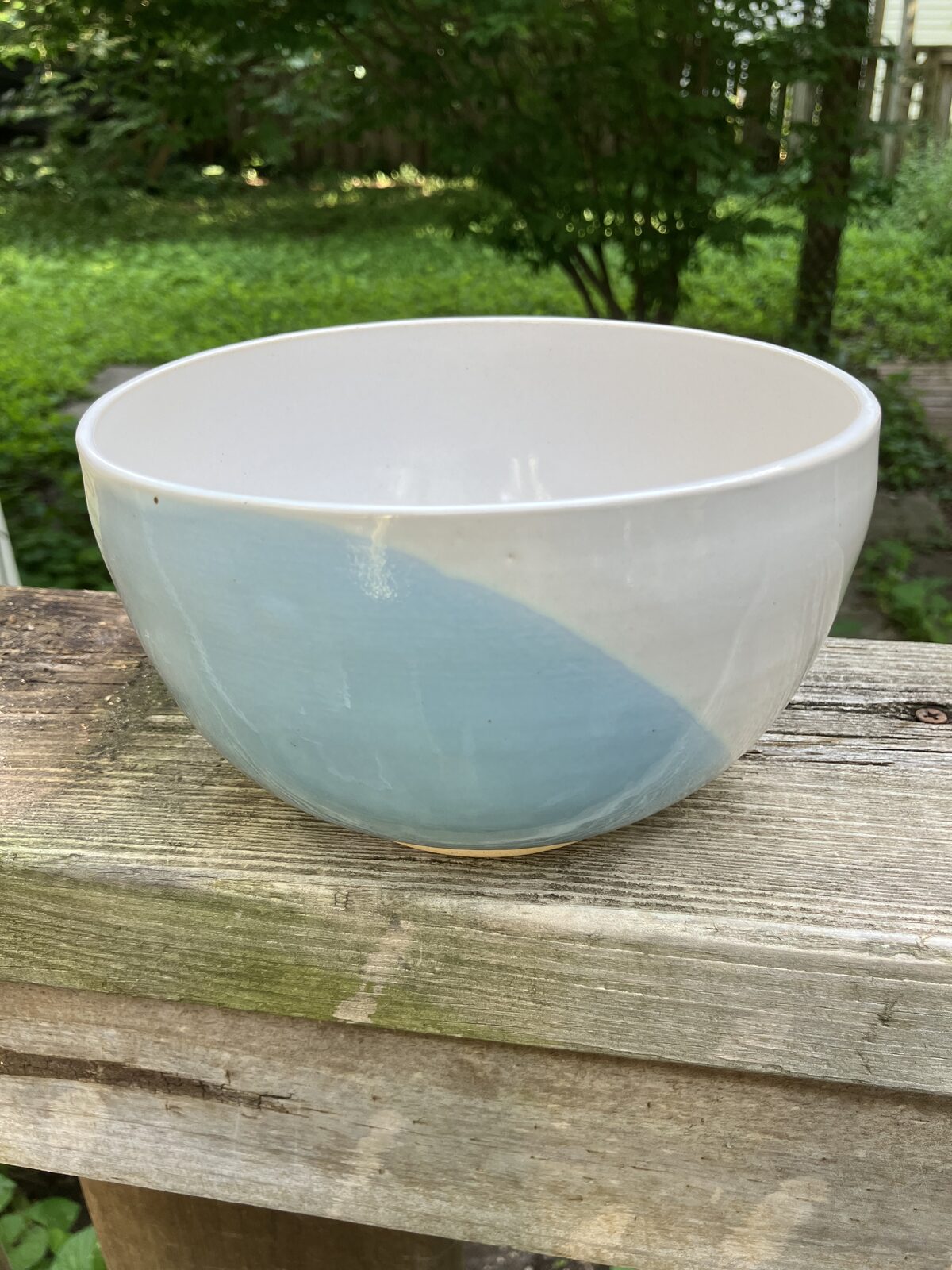 White ceramic bowl dipped in aqua glaze