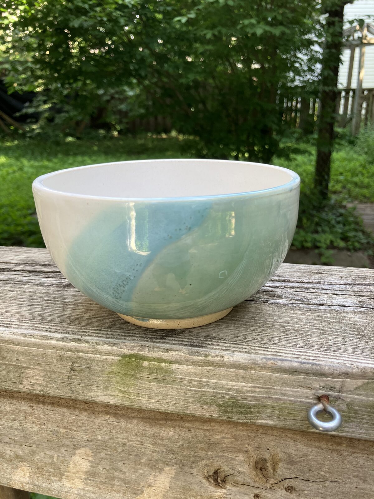 White ceramic bowl dipped in teal glaze