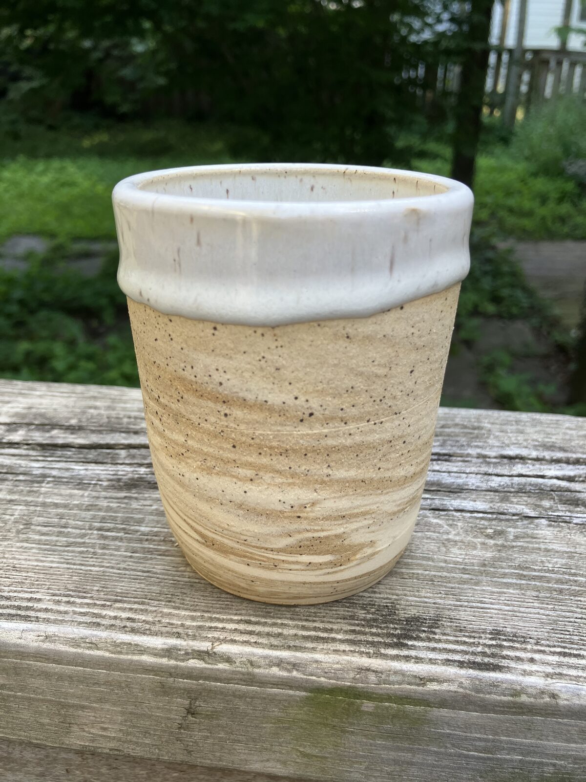Tall sandstone-colored ceramic tumbler with white rim