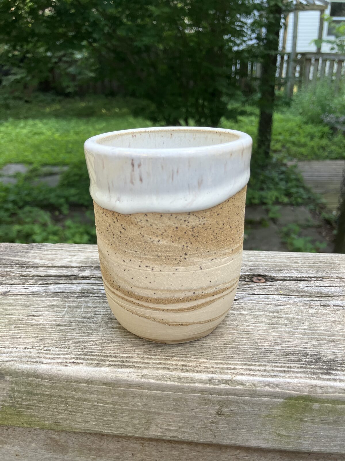 Short sandstone-colored ceramic cup with white rim